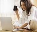 vrouw die thuis werkt op laptop met koffie